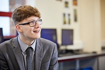 Male student in grey uniform smiling 