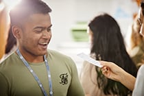 Smiling male students receiving results