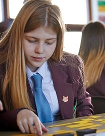 Female student using post it notes on desk