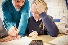 Teacher supporting student with work in the classroom