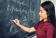 Teacher writing on a chalk board