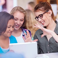 Teacher helping two students
