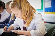 Maths student writing on notepad