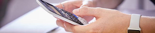 Hands using a calculator - Maths newsletter 