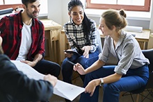 3 students working with a teacher